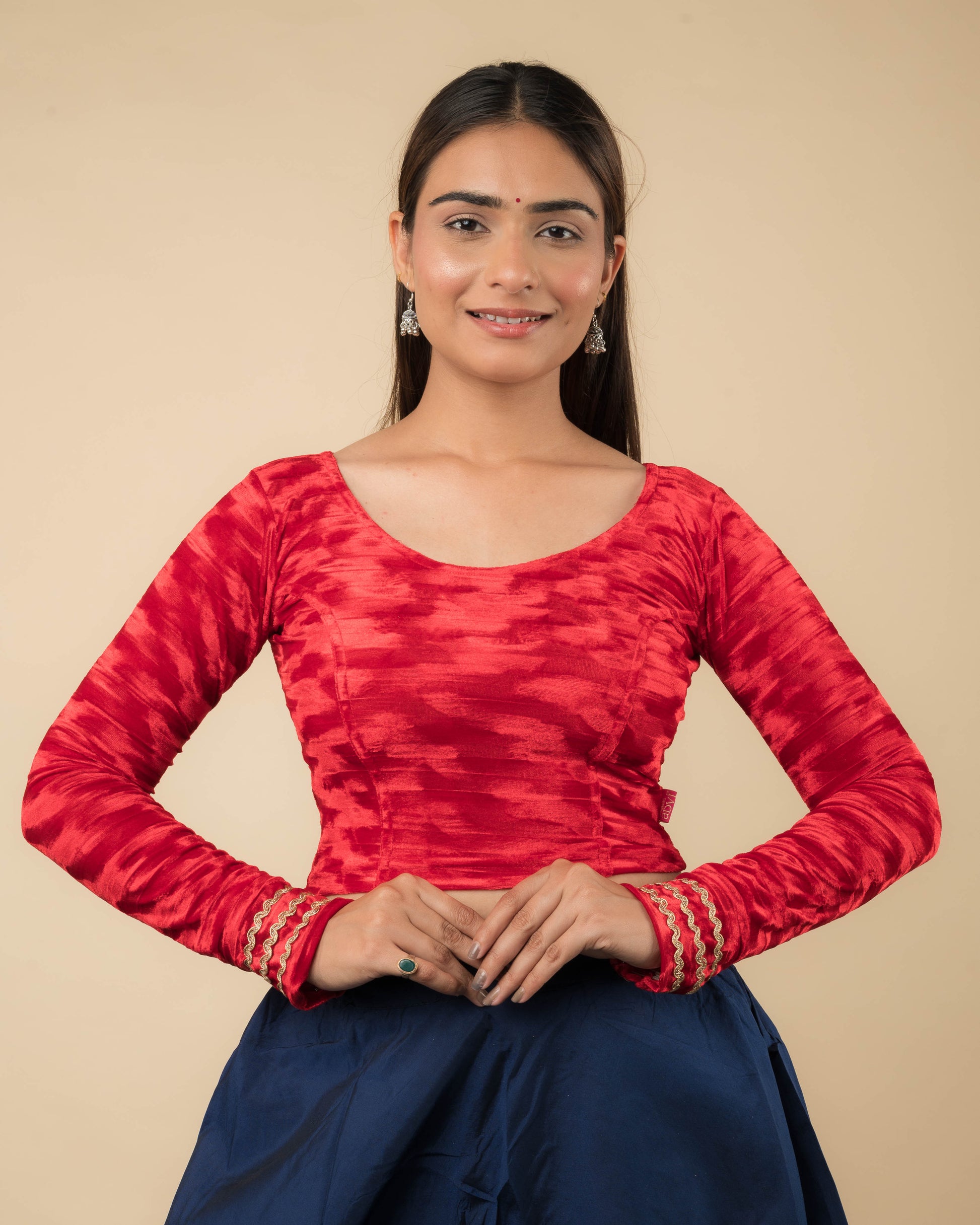 Model wearing a velvet stretchable readymade blouse with full sleeves and round neckline.