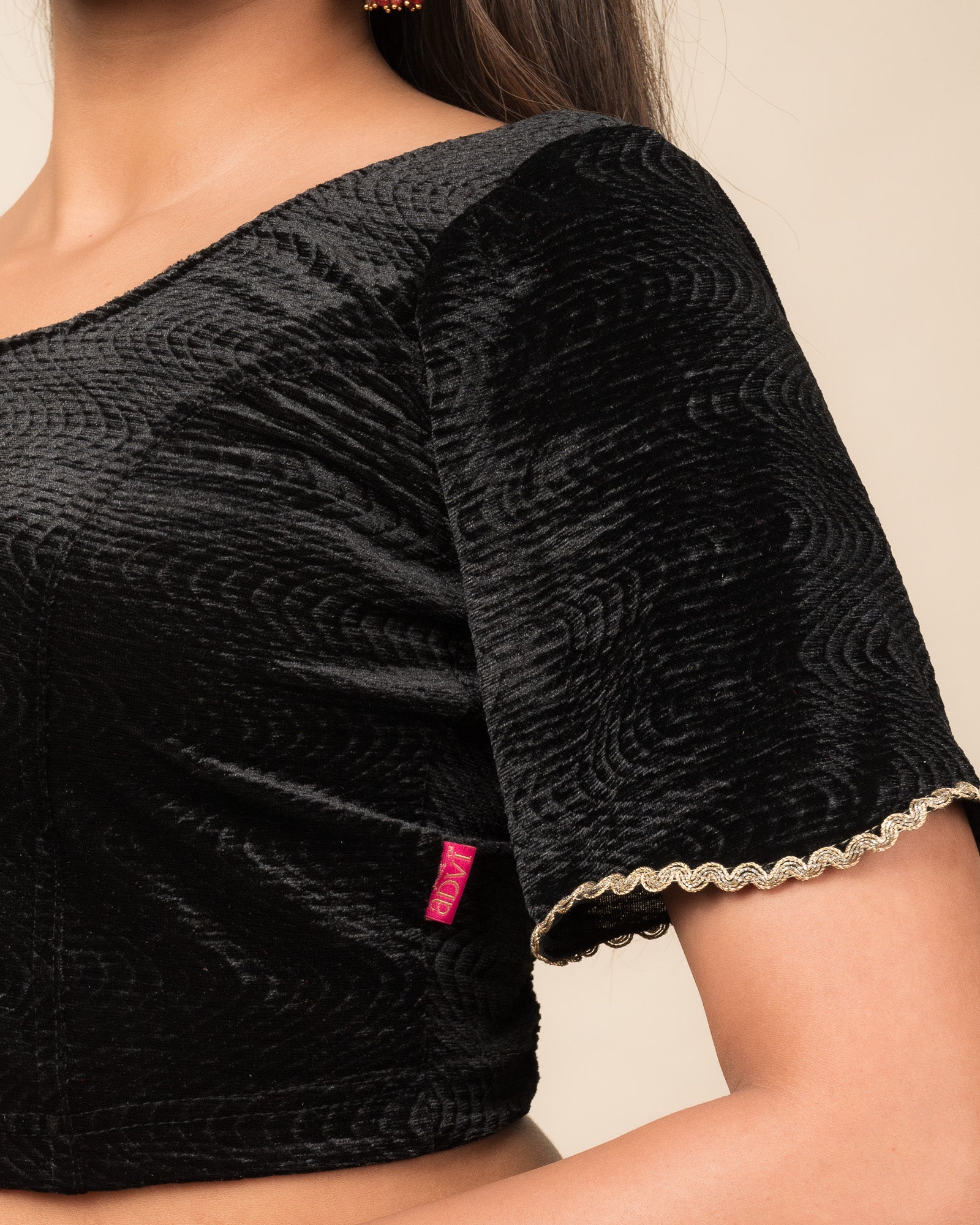 Close-up of the velvet fabric detailing the lace embroidery and stretchability of the readymade blouse.