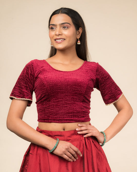 Model wearing a velvet stretchable readymade blouse with elbow-length bell sleeves and round neckline.