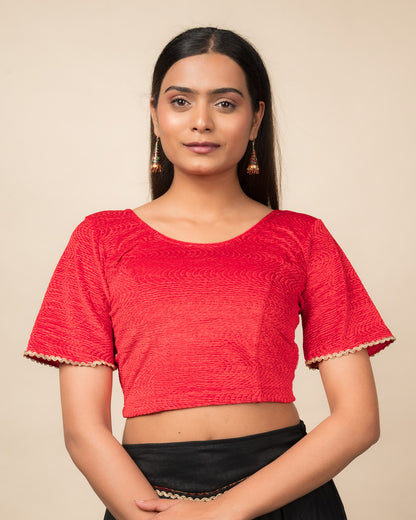 Model wearing a velvet stretchable readymade blouse with elbow-length bell sleeves and round neckline.