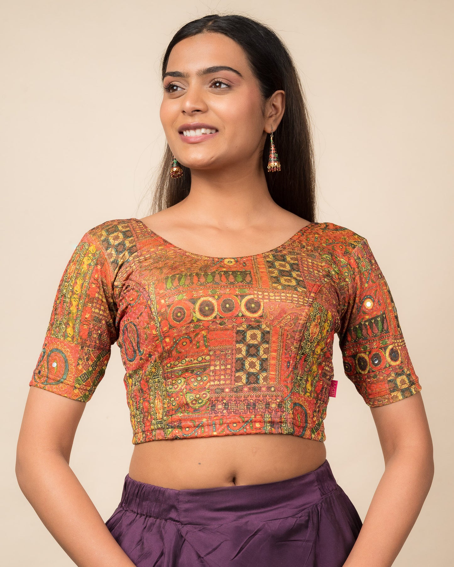 Model wearing a stretchable blouse with elbow sleeves and round neckline featuring ethnic mirror embellishments.