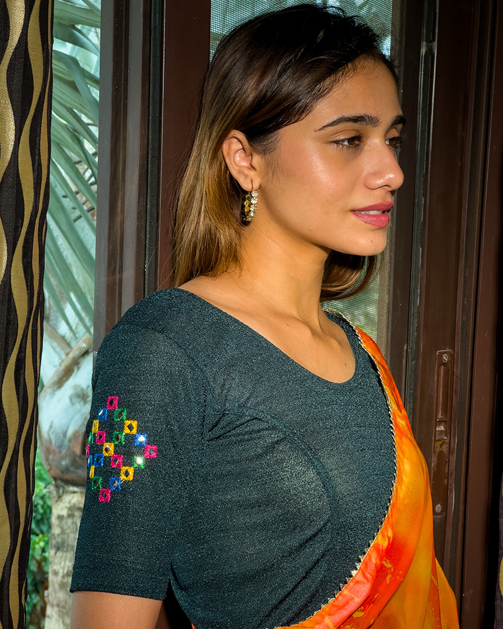 Model wearing a stretchable blouse with mirror embroidery on the neckline and sleeves.