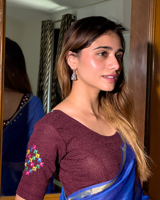 Model wearing a stretchable blouse with mirror embroidery on the neckline and sleeves.