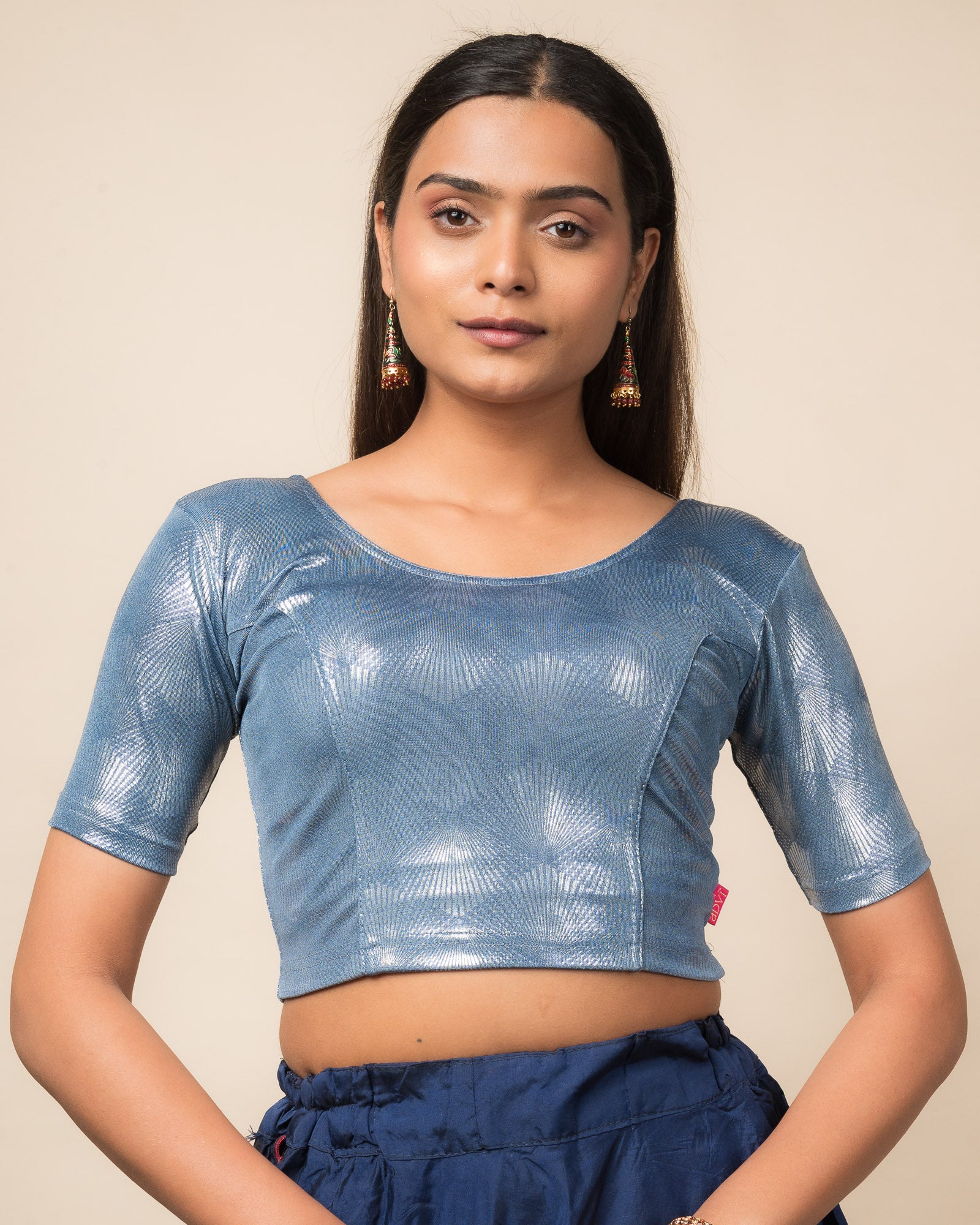 Model wearing a stretchable slip-on blouse with round neckline and elbow sleeves, showcasing a sleek metallic finish.
