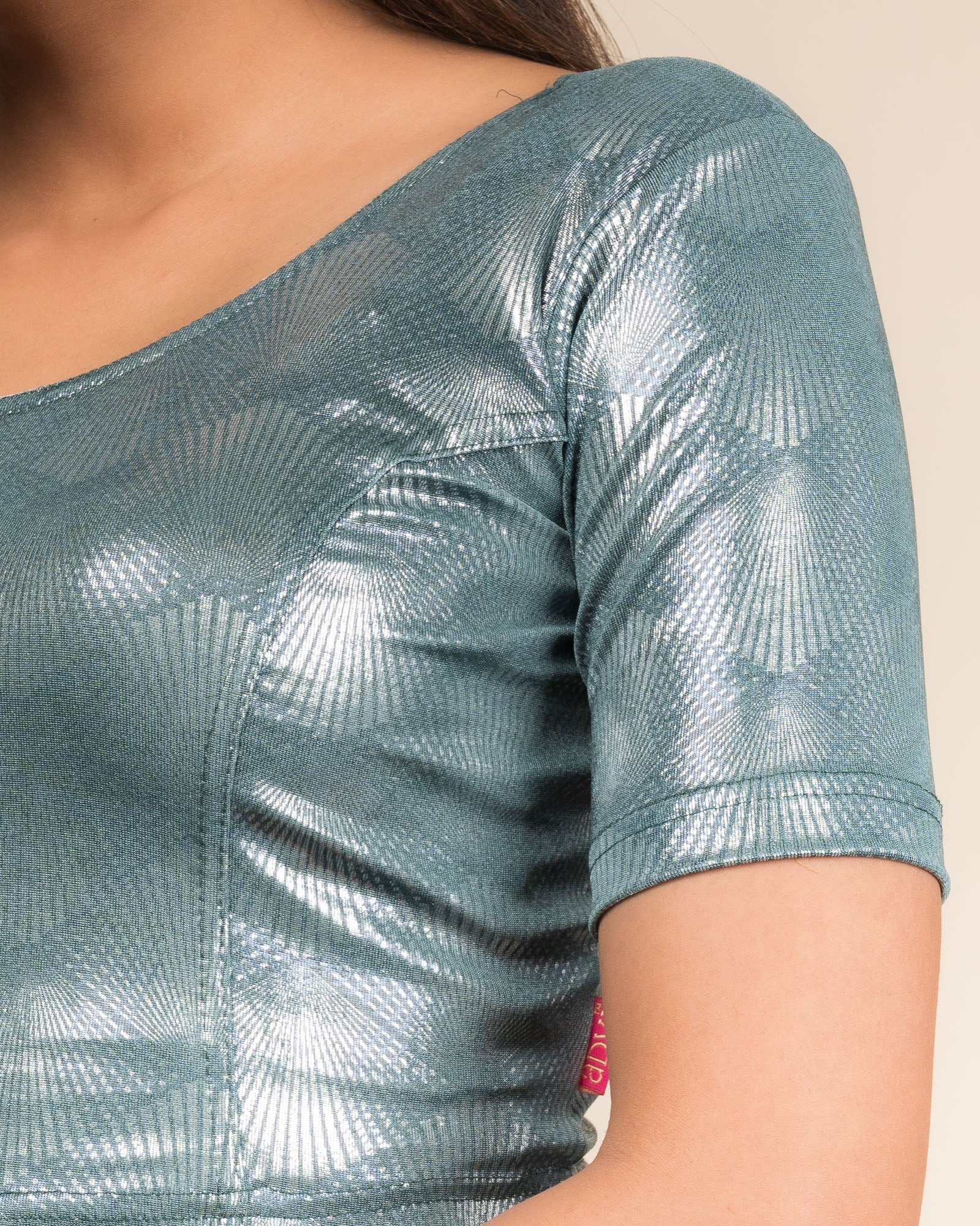 Close-up of the jacquard knit fabric with glittery metallic detailing.