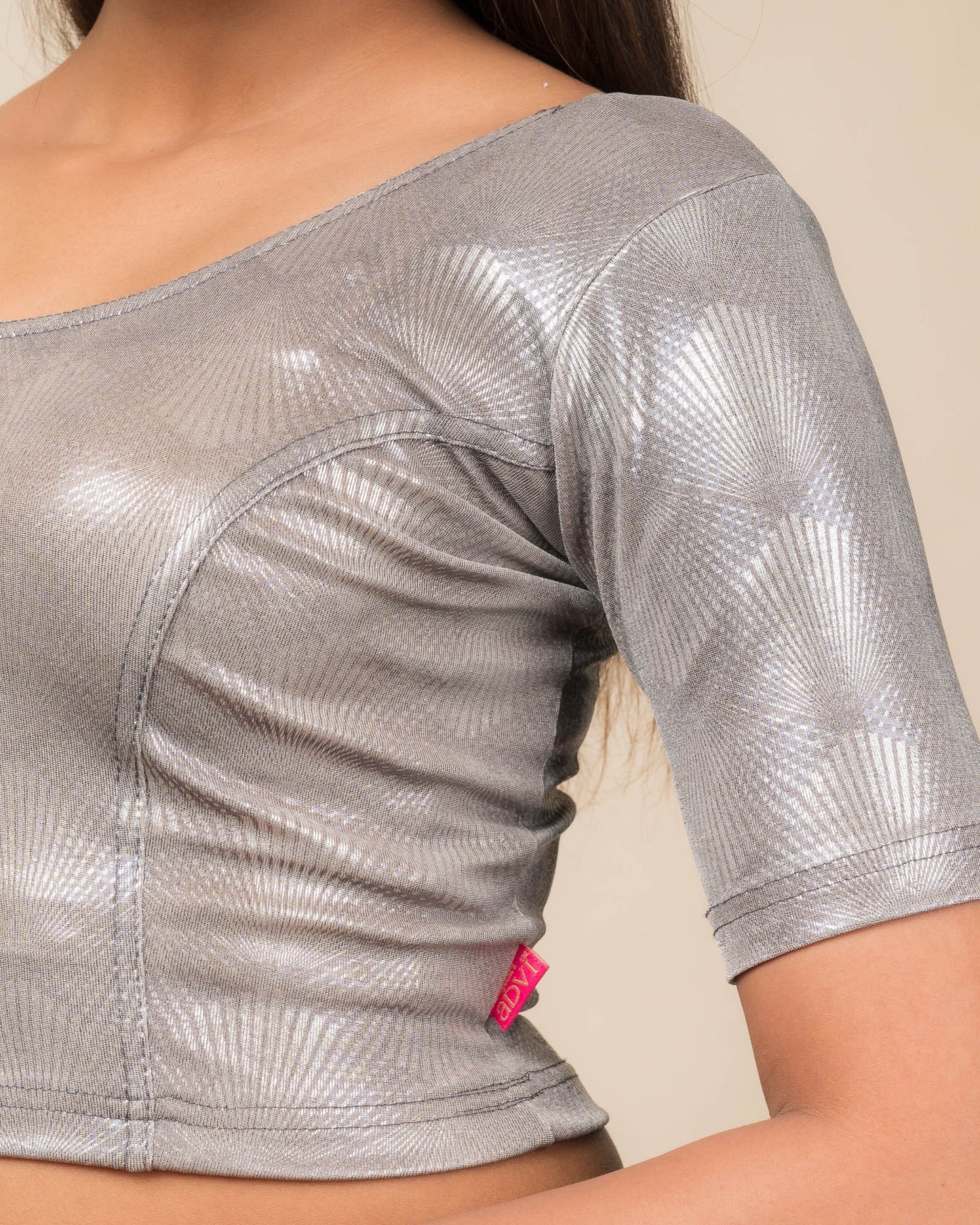 Close-up of the jacquard knit fabric with glittery metallic detailing.
