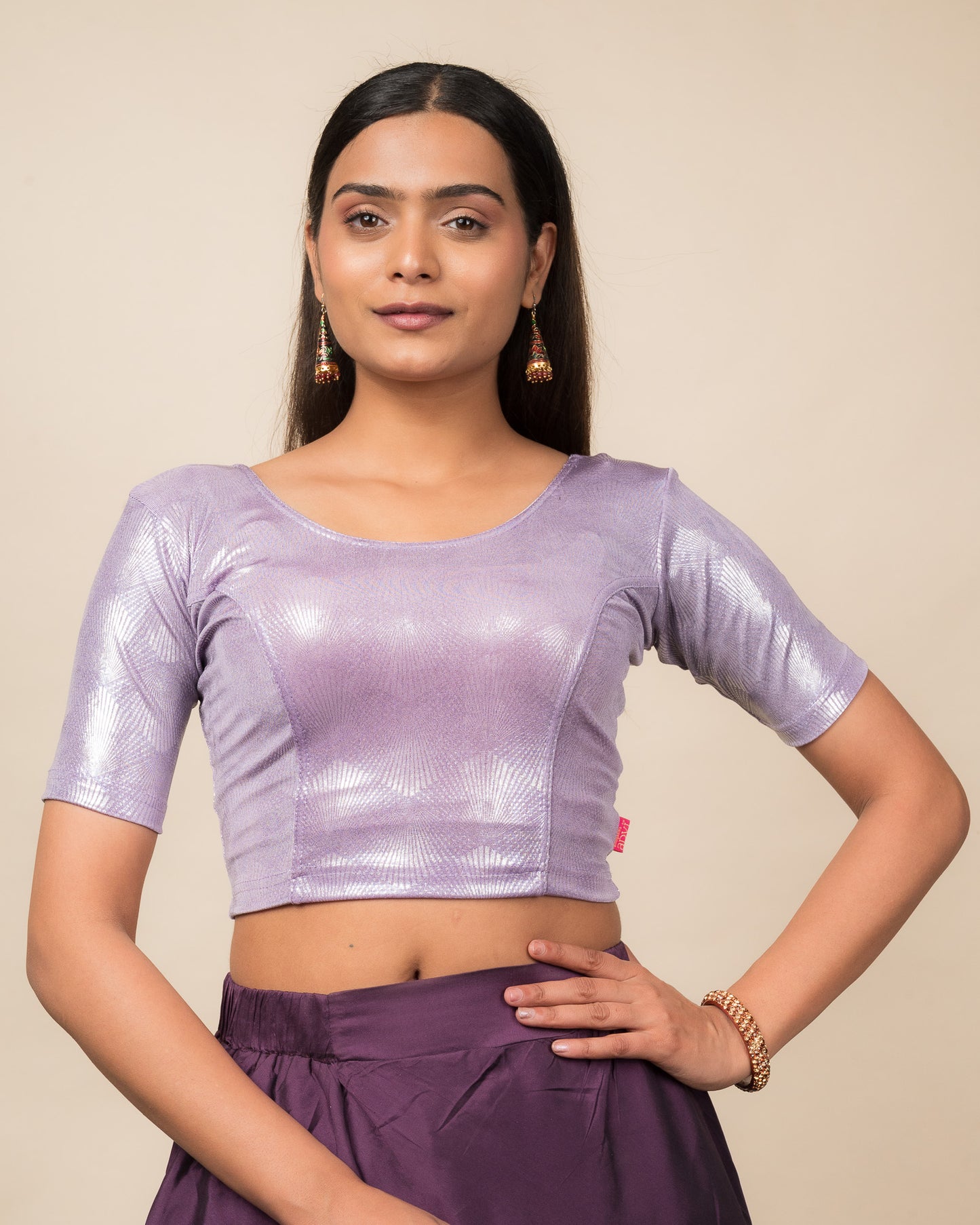 Model wearing a stretchable slip-on blouse with round neckline and elbow sleeves, showcasing a sleek metallic finish.