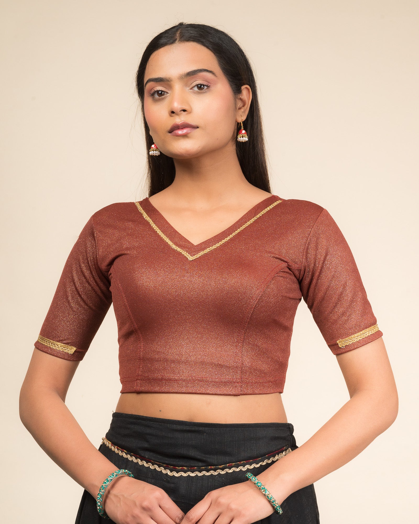 Model wearing a stretchable blouse with elbow sleeves and a V-neckline featuring metallic sheen.