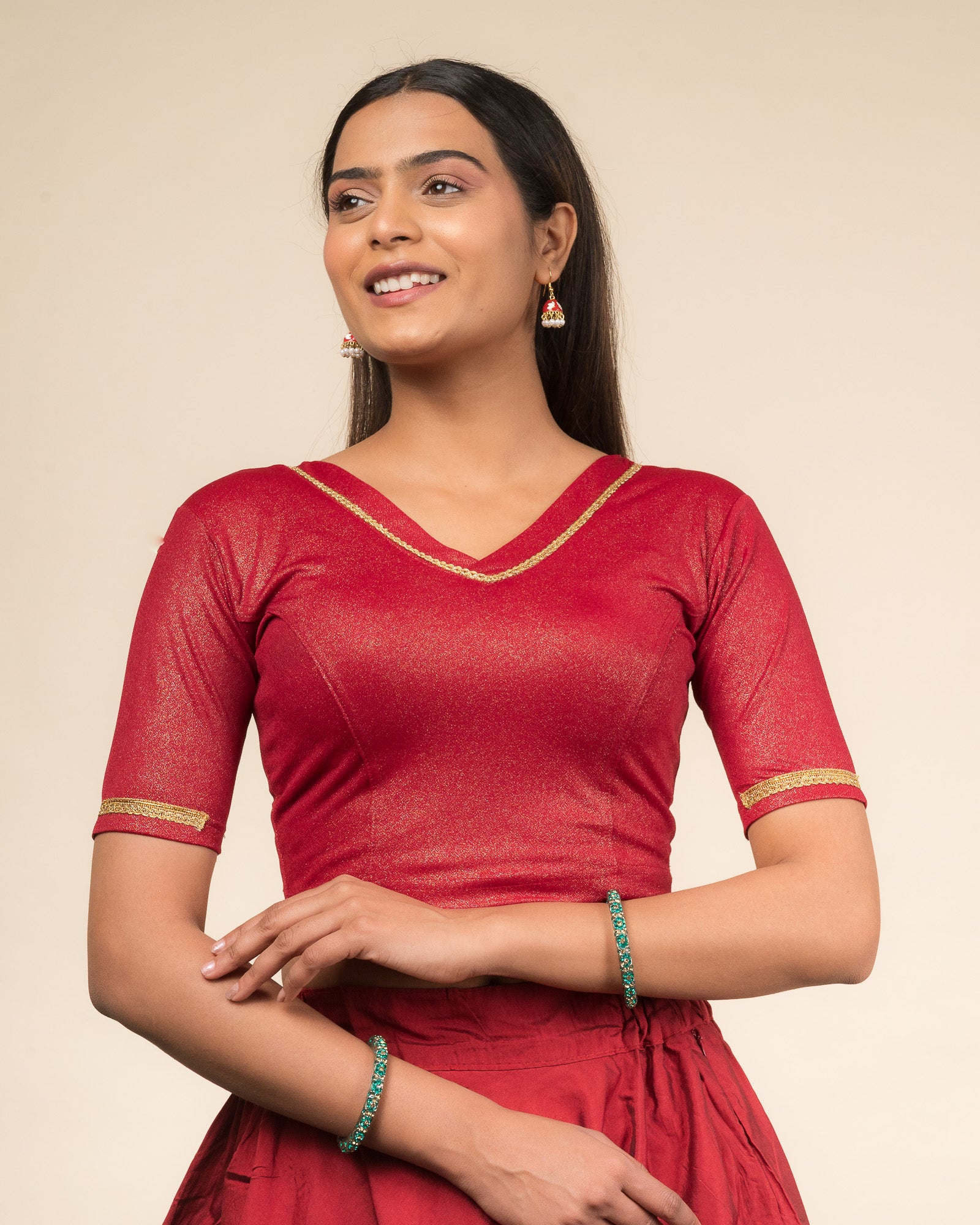 Model wearing a stretchable blouse with elbow sleeves and a V-neckline featuring metallic sheen.