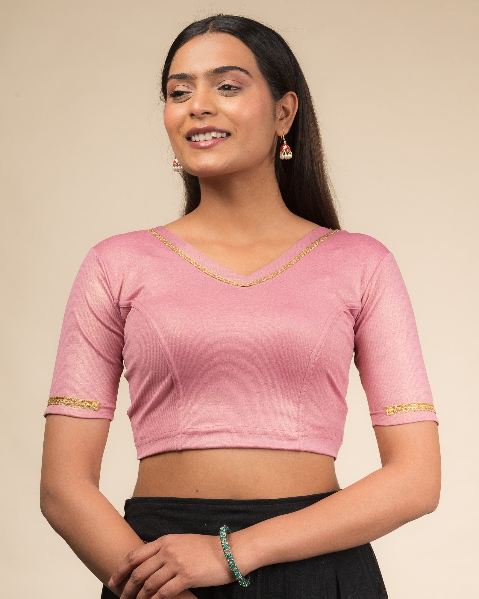 Model wearing a stretchable blouse with elbow sleeves and a V-neckline featuring metallic sheen.