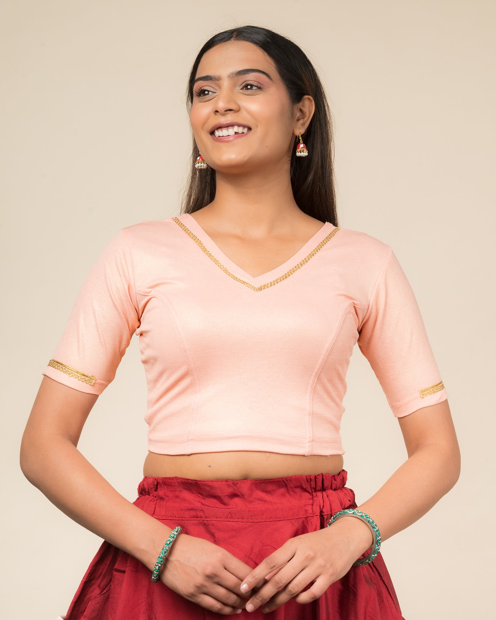Model wearing a stretchable blouse with elbow sleeves and a V-neckline featuring metallic sheen.