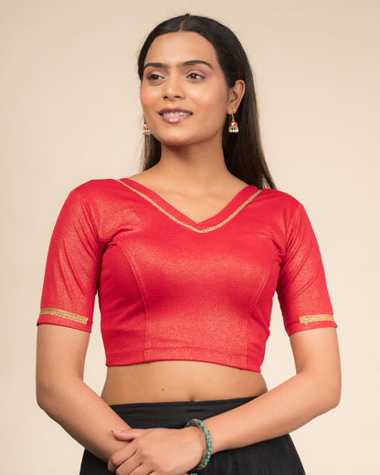 Model wearing a stretchable blouse with elbow sleeves and a V-neckline featuring metallic sheen.
