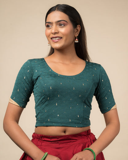 Model wearing a stretchable blouse with round neckline and elbow sleeves featuring metallic drop motifs.
