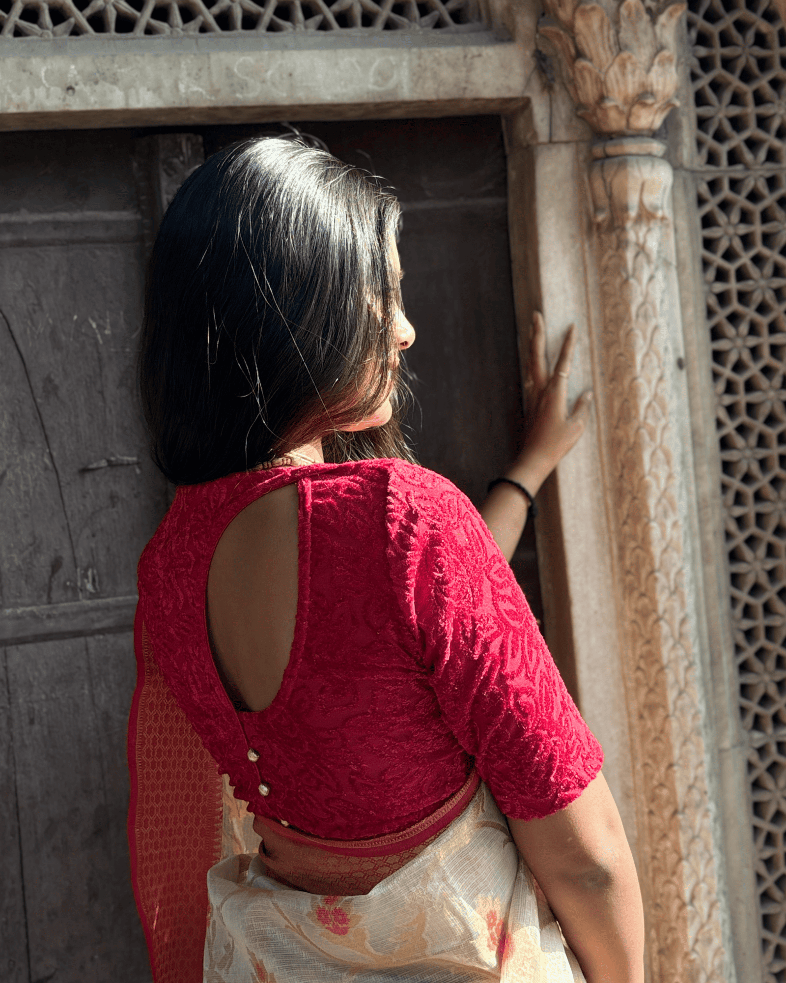 Rear view of the tone-sparkle stretchable blouse showcasing the designer back cut with potli buttons.