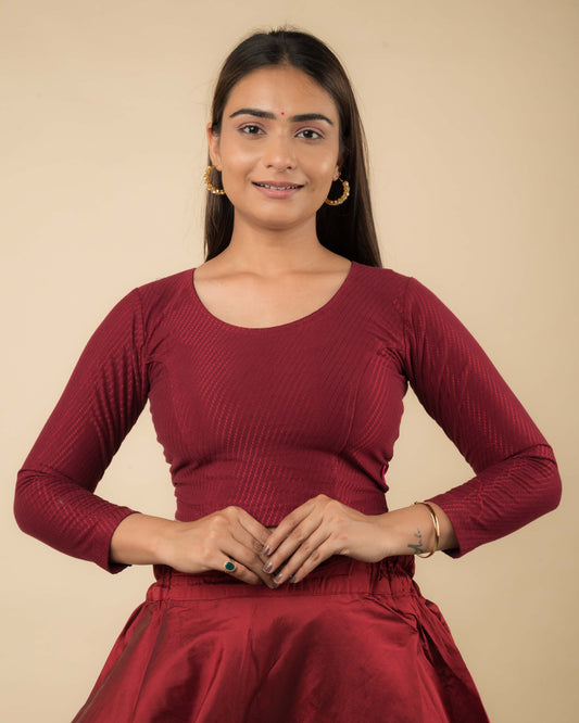 Model wearing a stretchable dobby-weave cotton blouse with long sleeves and round neckline