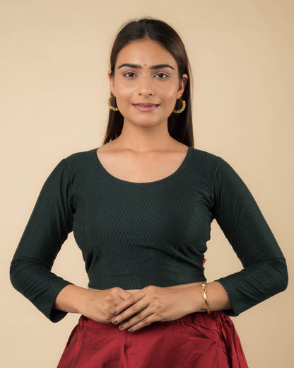Model wearing a stretchable dobby-weave cotton blouse with long sleeves and round neckline