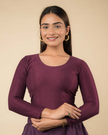 Model wearing a stretchable dobby-weave cotton blouse with long sleeves and round neckline