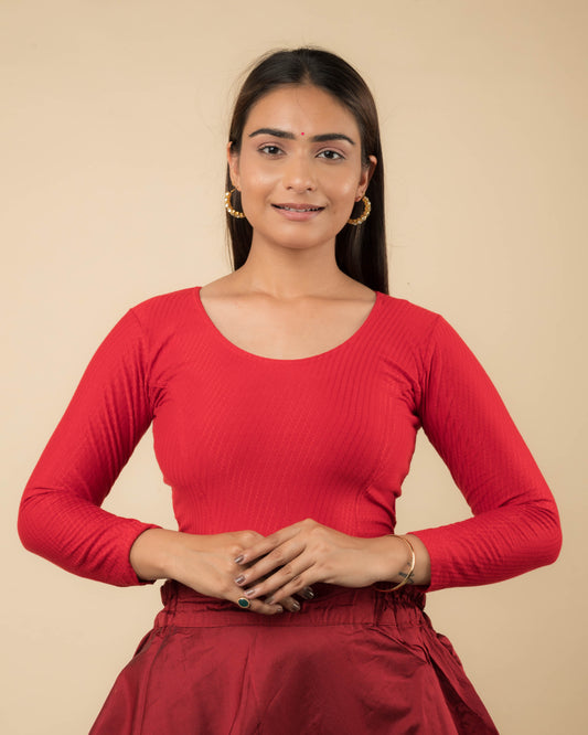 Model wearing a stretchable dobby-weave cotton blouse with long sleeves and round neckline