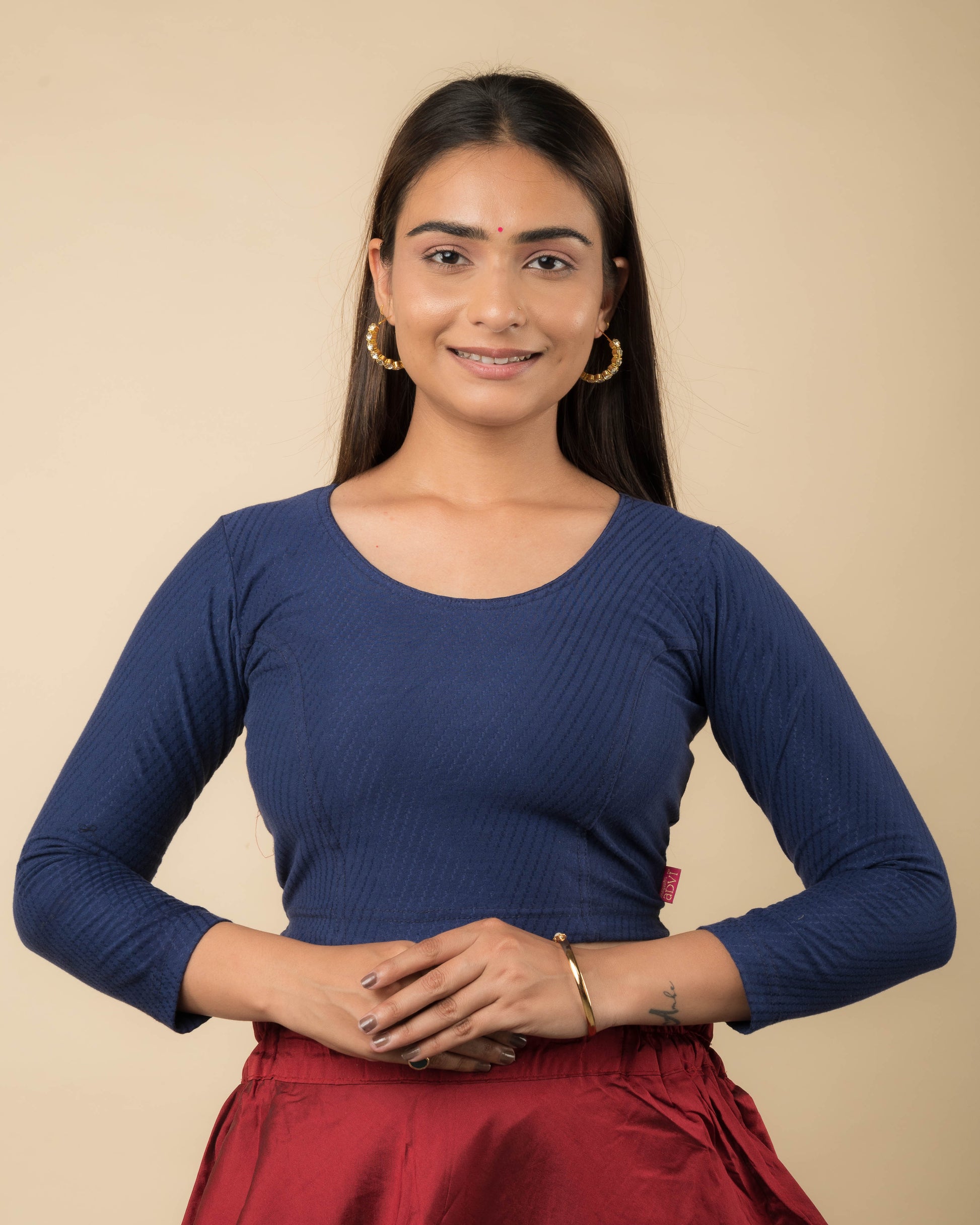 Model wearing a stretchable dobby-weave cotton blouse with long sleeves and round neckline