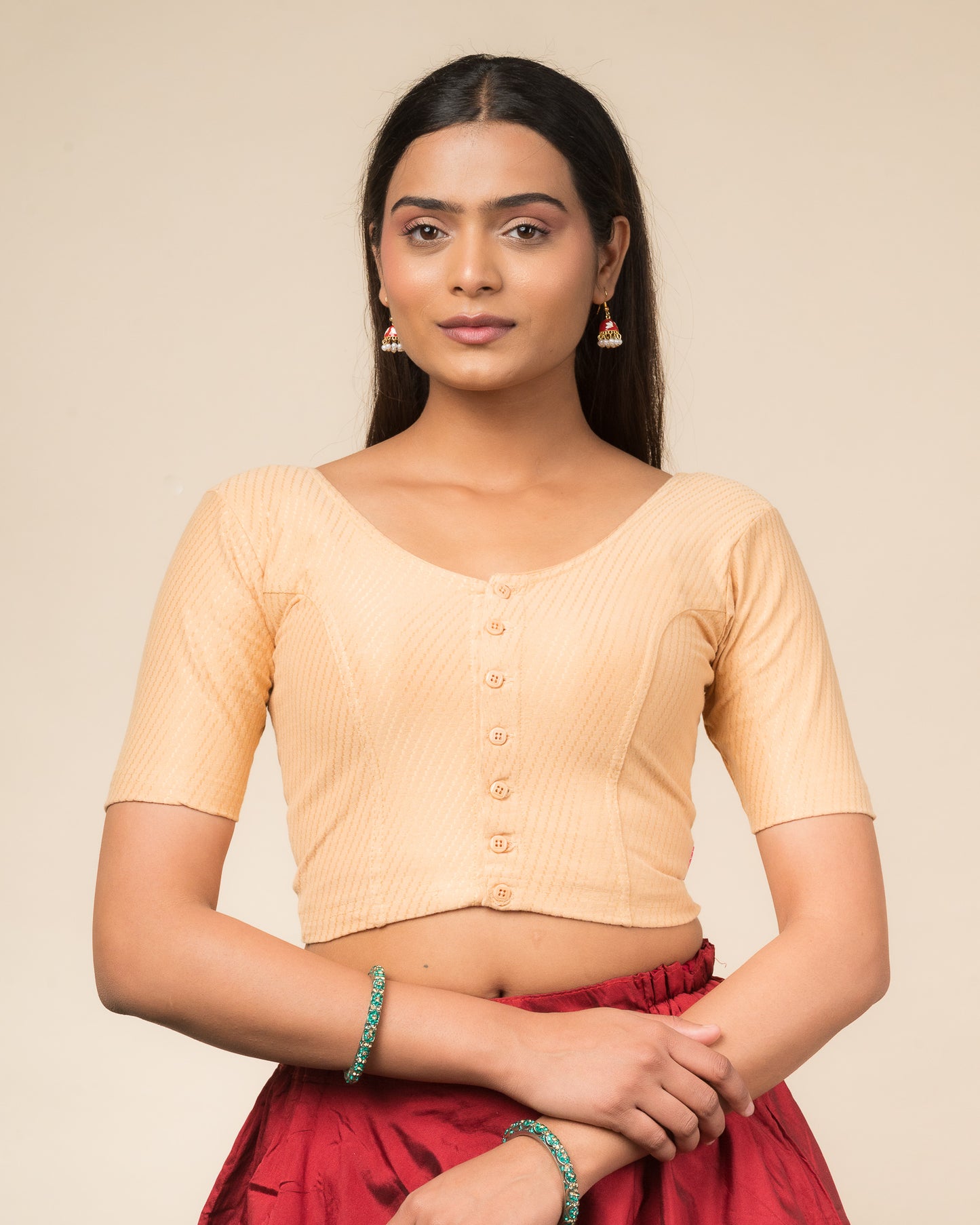 Model wearing a stretchable dobby-weave cotton blouse with elbow sleeves, round neckline, and front-button closure