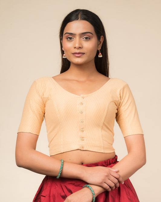 Model wearing a stretchable dobby-weave cotton blouse with elbow sleeves, round neckline, and front-button closure