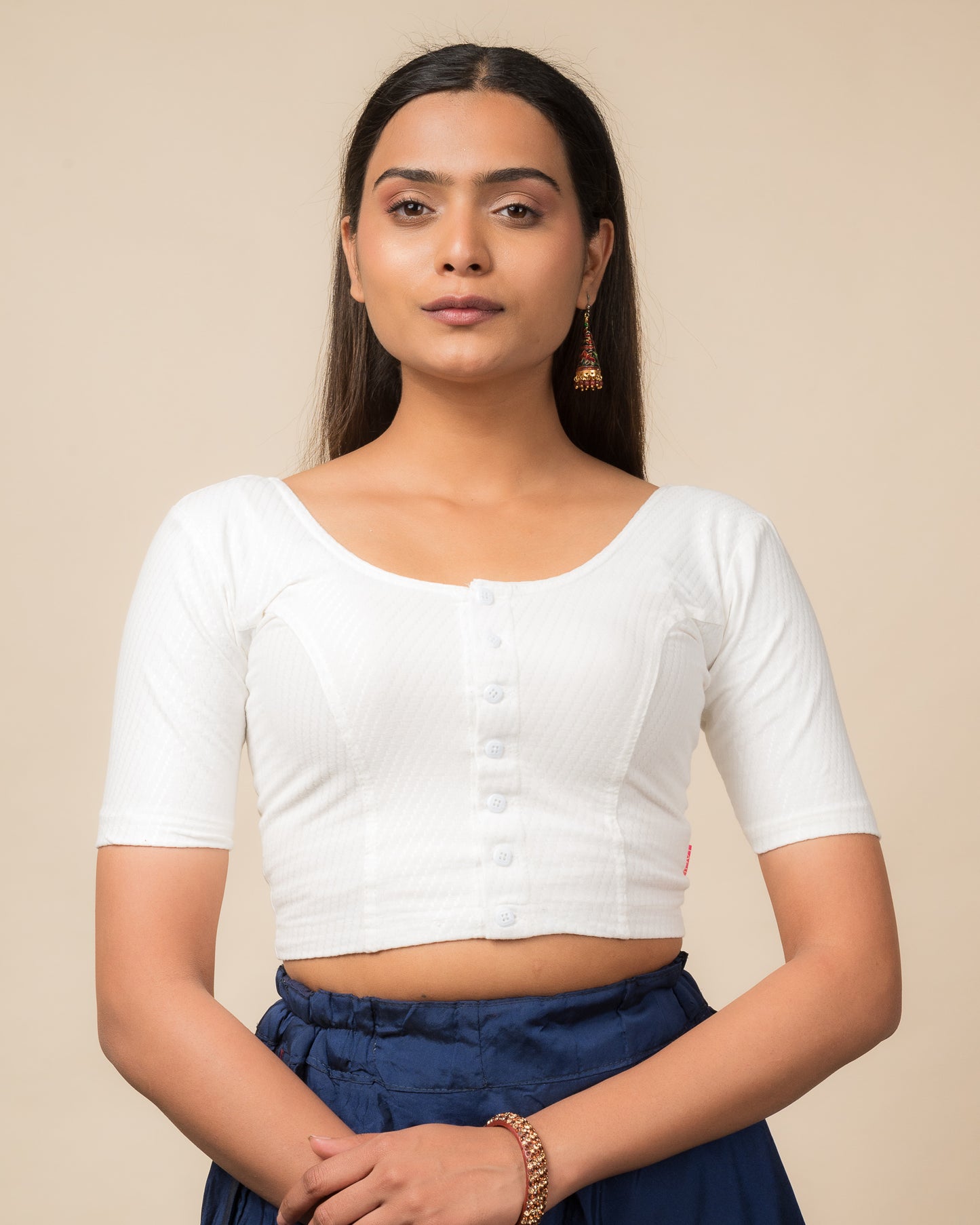 Model wearing a stretchable dobby-weave cotton blouse with elbow sleeves, round neckline, and front-button closure