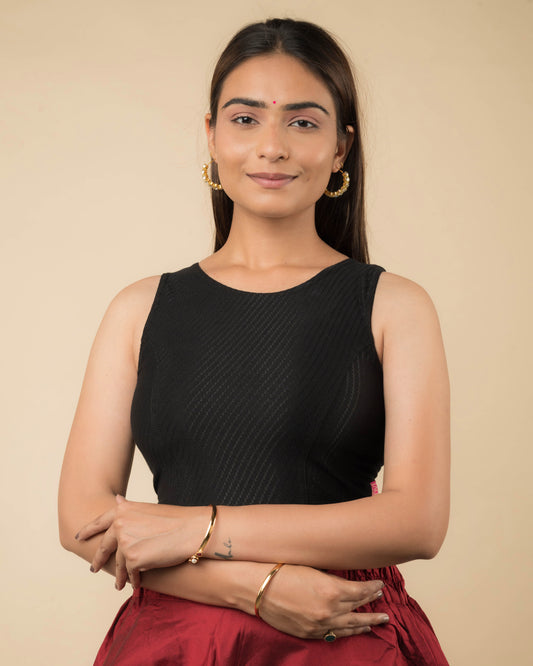 Model wearing a sleeveless stretchable cotton blouse with high neckline