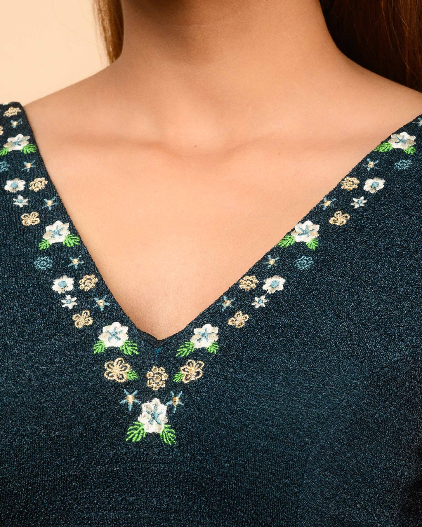 Navy blue garment with floral embroidery on a beige background