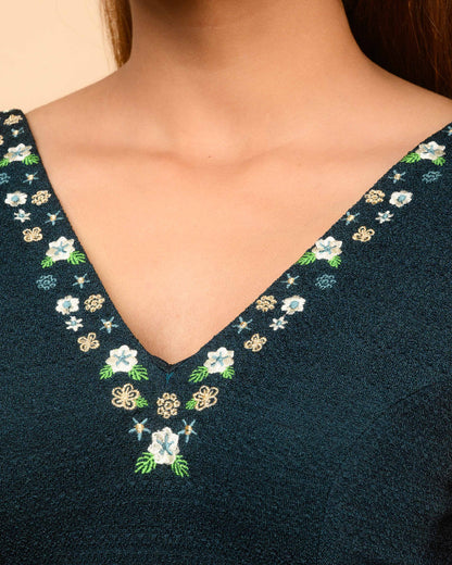 Navy blue garment with floral embroidery on a beige background