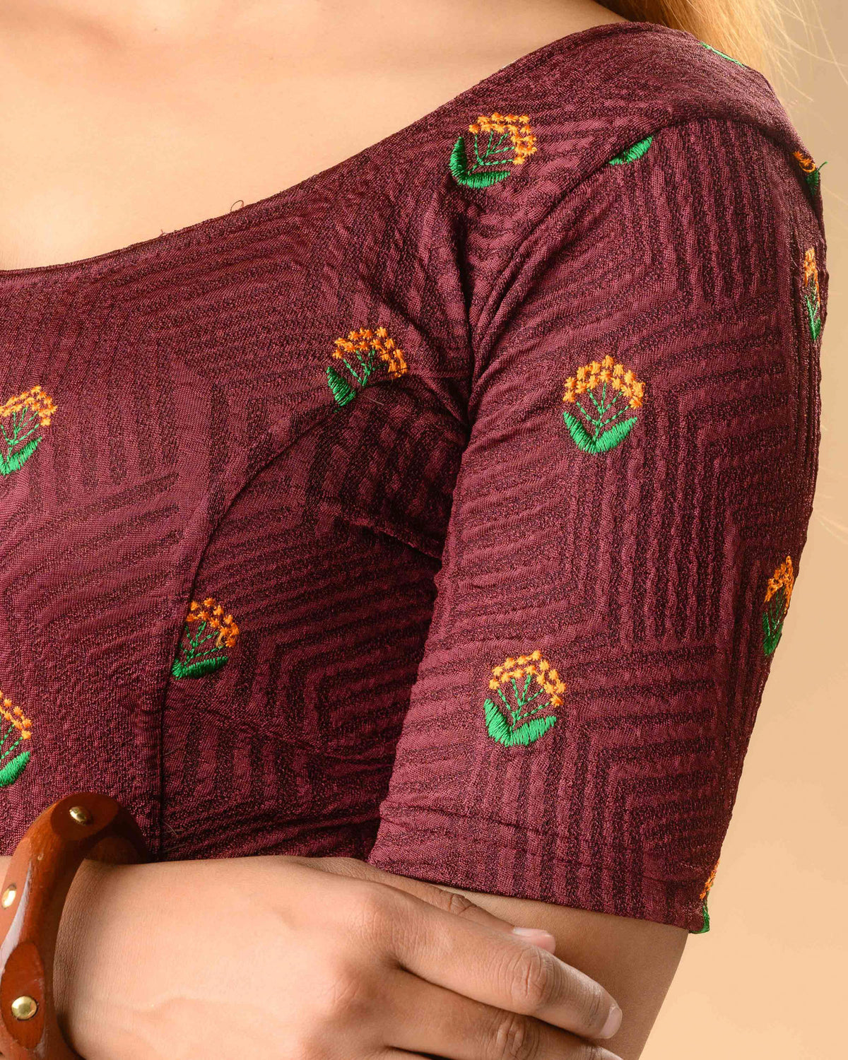 Close up of orange and green resham buti on Keerti Wine jacquard blouse by Advi - detail