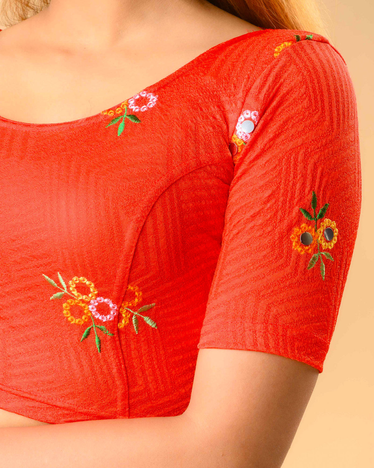 Close up of resham flowers and mirror work on the Jheeni red blouse by Advi - detail