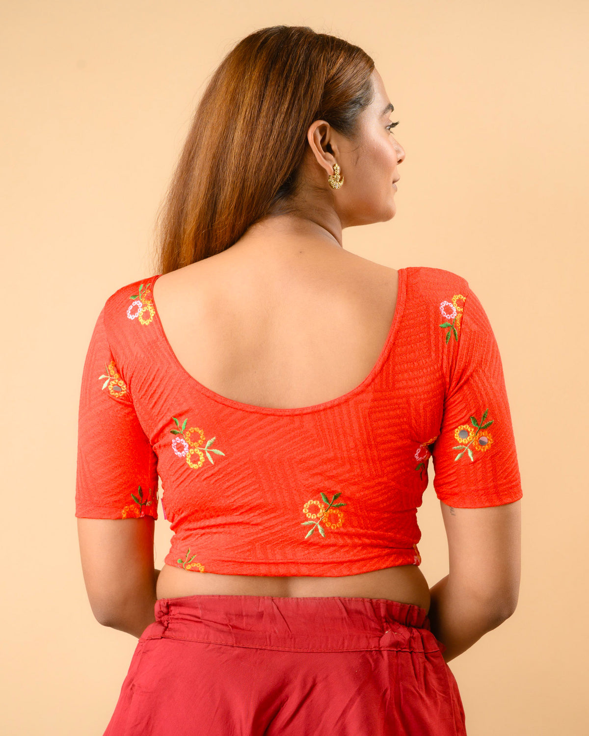 Jheeni red blouse showing the deep U back with floral buti by Advi - back
