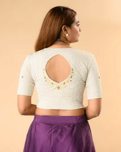 Yamini cream blouse with teardrop keyhole and gold zari floral border by Advi - back